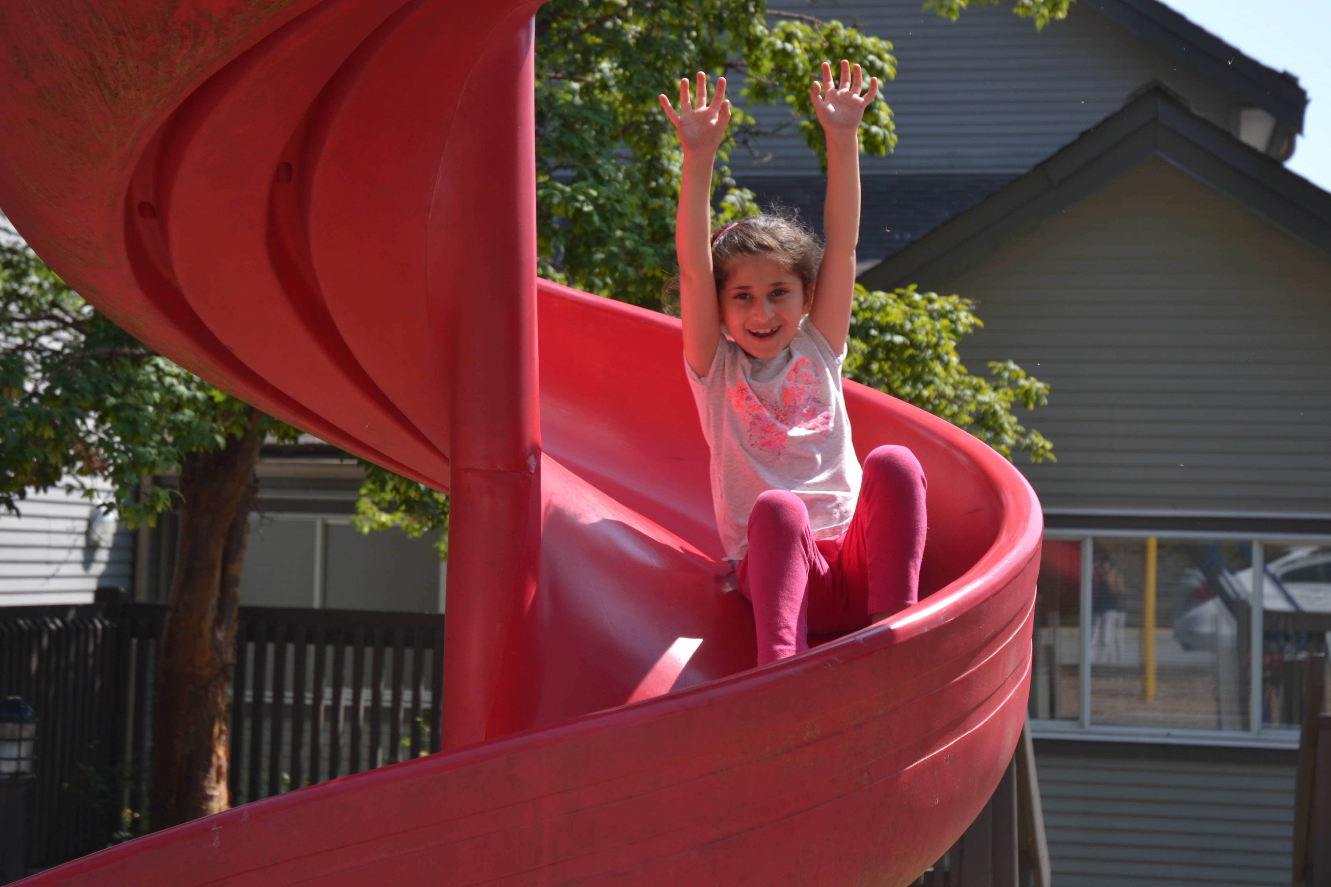 Young girl on a playground slide - Resident of Red Door Housing