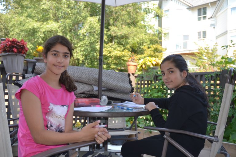 Sisters smiling at an outdoor table - Residents of Red Door Housing